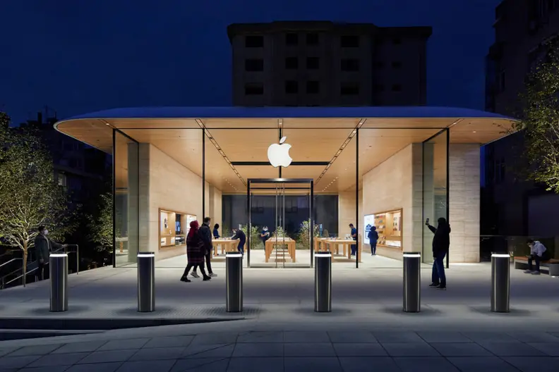 An Apple store open and lit in the dark.