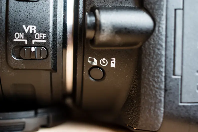 The drive mode button is placed in a rather inconvenient location under the lens mount.