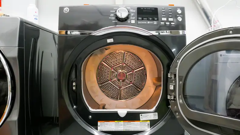 A close-up of the tungsten-lit interior of the GE GFD45ESPM1DG dryer's 7.5 cu. ft. drum.