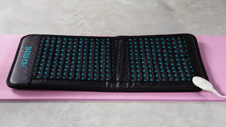 The Higher Dose PEMF Go Mat on a pink yoga mat.