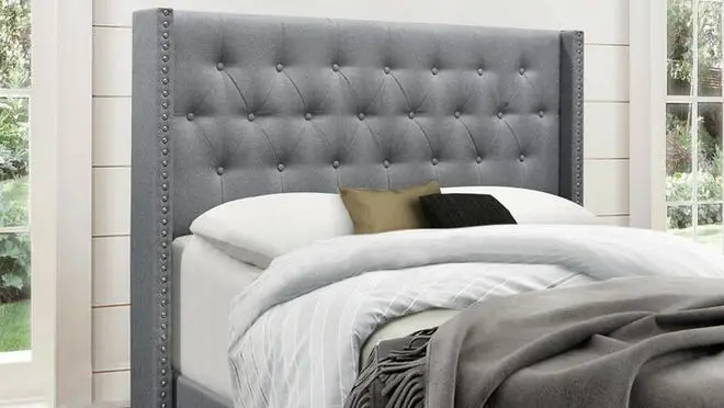 Gray tufted bed in bedroom