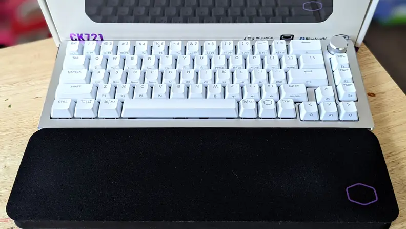 A white keyboard above a black wrist rest
