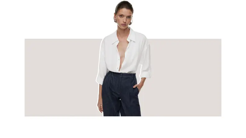 A model wearing a white button-up shirt.