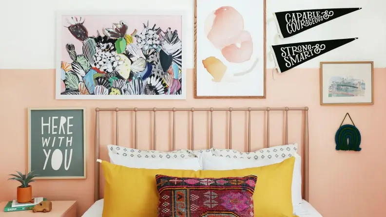Gallery wall with prints and pennant flags above a bed