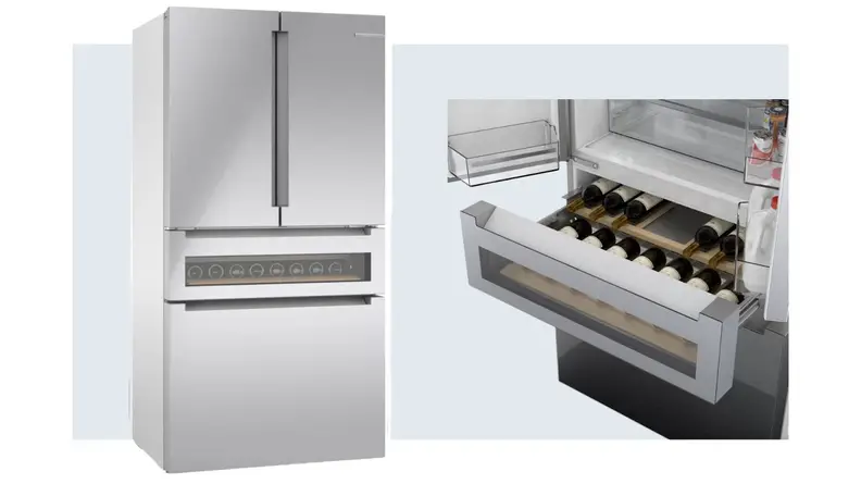 On left, stainless steel LG LRMVS3006S double-door refrigerator. On right, several bottles of red wine stacked inside of the Bosch Refreshment Center within the Bosch B36CL81ENG refrigerator.