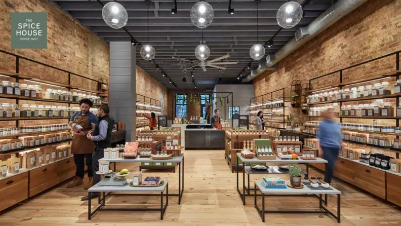Chicago Spice House Store, with exposed brick, jar-filled shelves, and tables spread throughout.