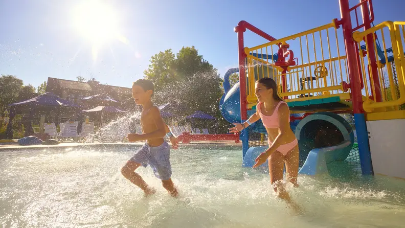 Two children splashing in a water park
