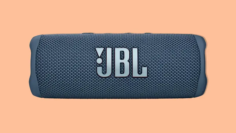 A navy blue JBL Flip 6 portable bluetooth speaker on an orange background.