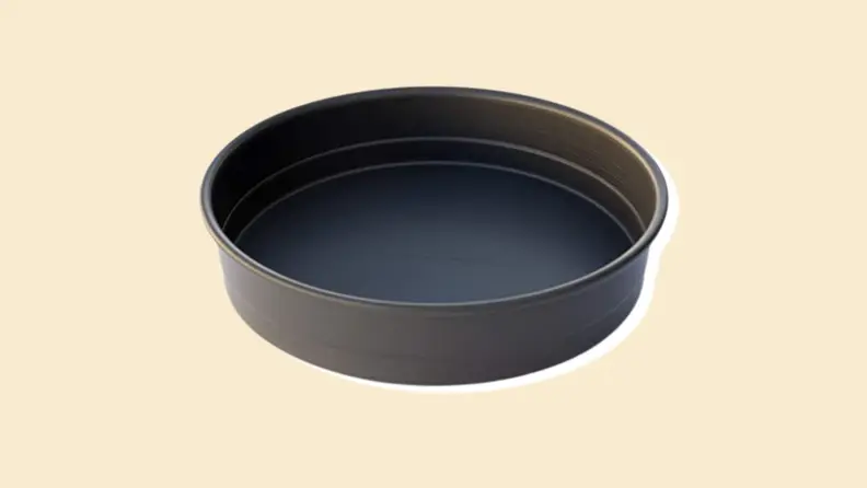 A round pan on a beige background.