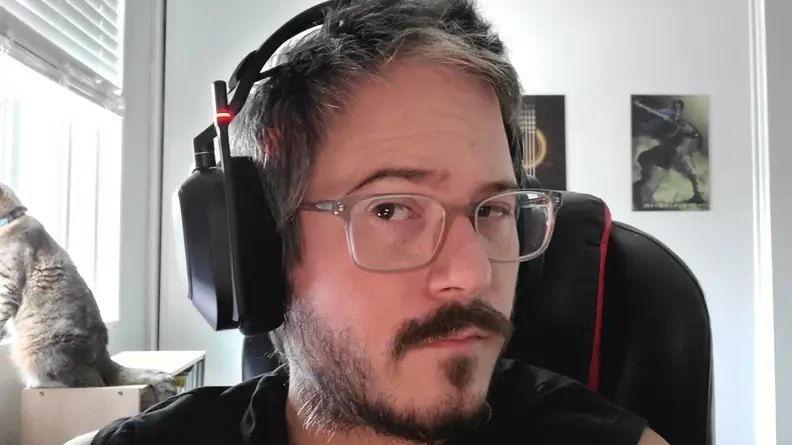 Man wearing the HS80 in muted position; there is a cat in the background