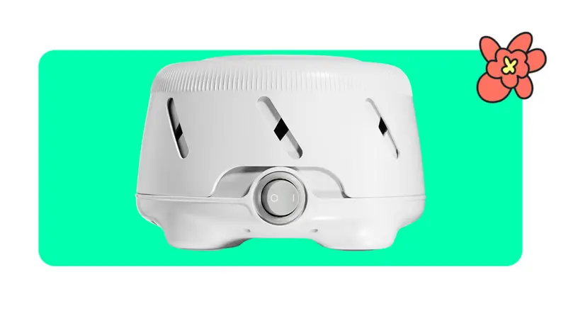 A white Yogasleep White Noise machine in front of a green background with a red cartoon flower in the corner.