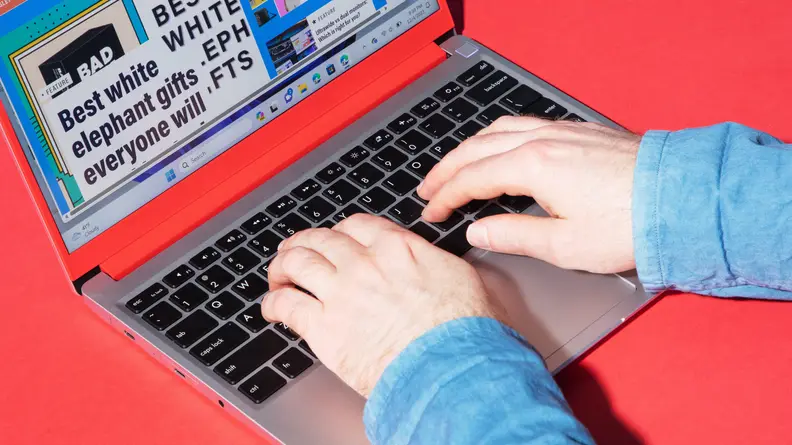 A pair of hands interacting with the laptop.