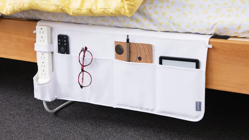 A bed caddy fits a power outlet, tablet, glasses, and notebook.