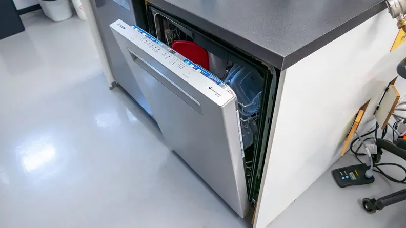 An angled shot of the dishwasher with the door partially open.