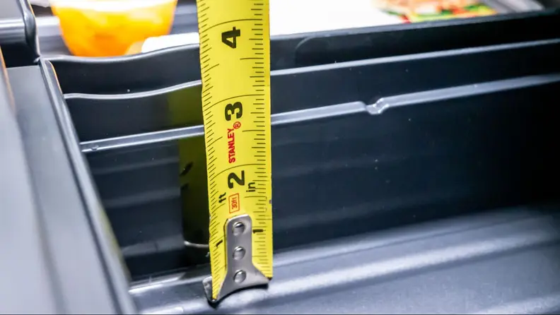 A tape measure showing the height of the Ninja FrostVault DryZone.