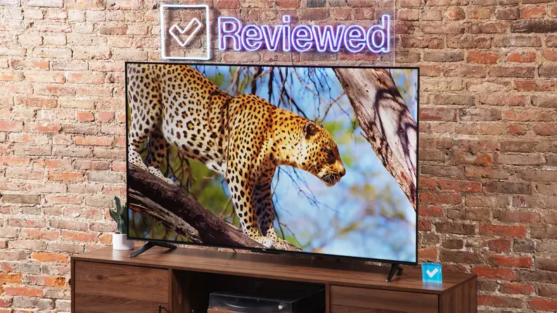 The TCL S4 LED TV on a wood entertainment center with a brick background.