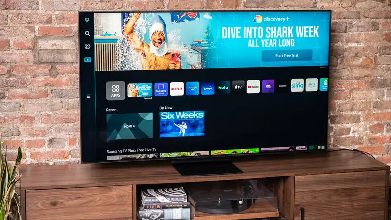 The Samsung QN90B displaying the home screen of its Tizen-based smart platform