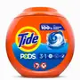 Three laundry pods placed next to folded towels