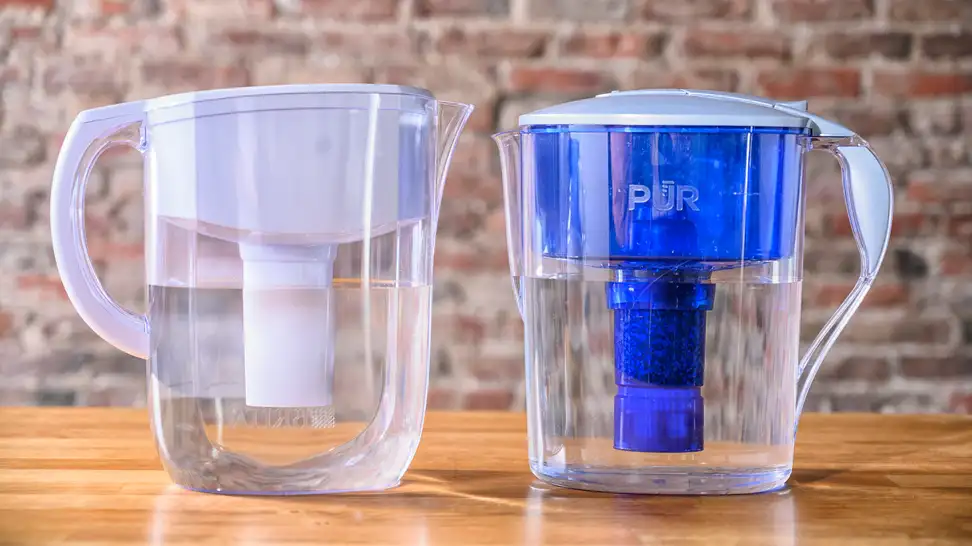 Two water pitchers against a brick wall