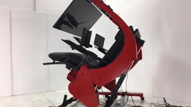 Red and black ergonomic workstation with large monitor tilted to a reclined position