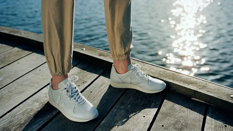 Someone wearing sneakers on a dock.