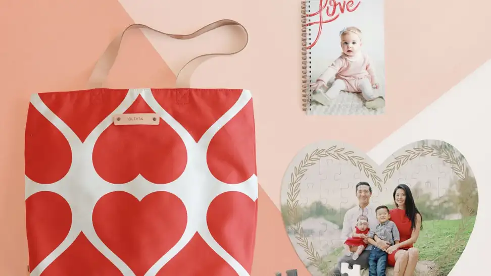 Tote bag, puzzle, and journal on pink background.