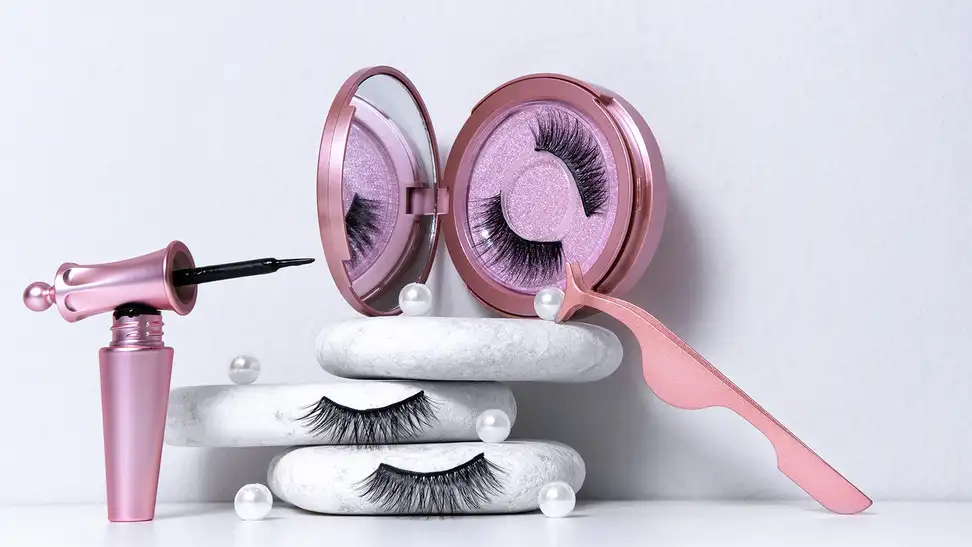 A set of magnetic eyelashes with the corresponding magnetic liner and tweezers staged on a white background.