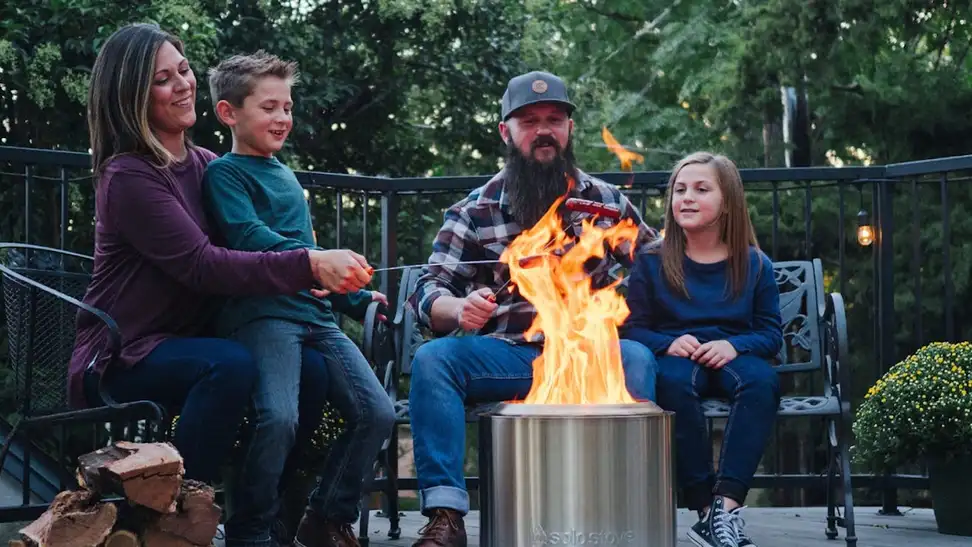 A family sits around their Solo Stove fire pit.