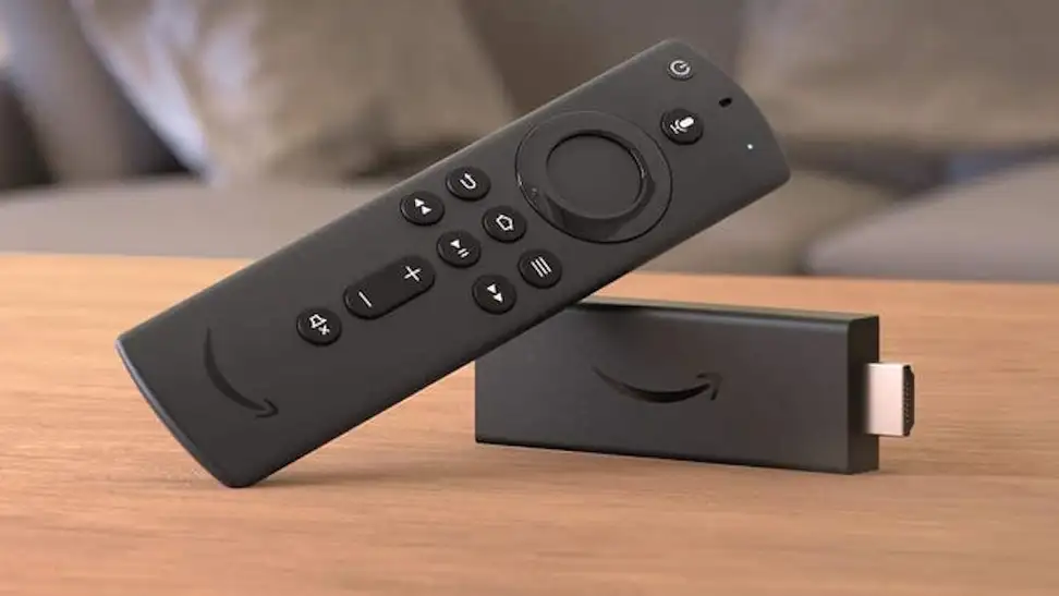An Amazon Fire Stick, streaming device, leaning against itself on a wooden tabletop.