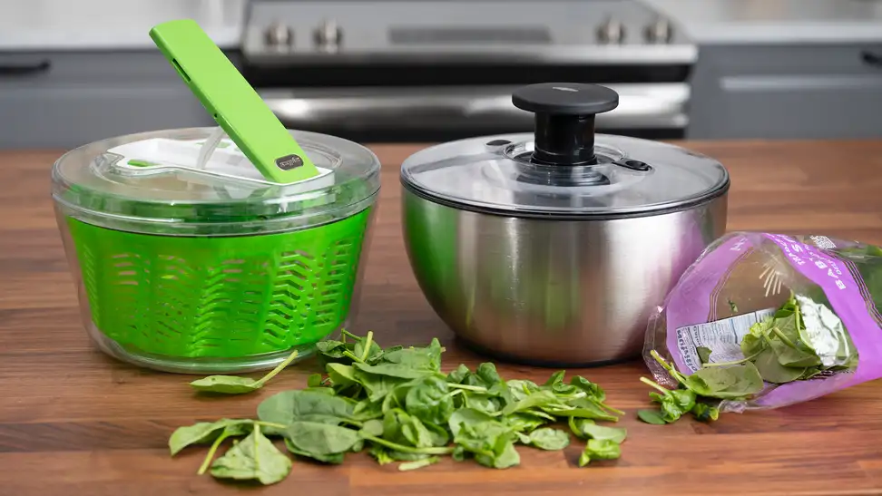 The Zyliss Dry and OXO Steel salad spinners sit side by side on a kitchen counter.