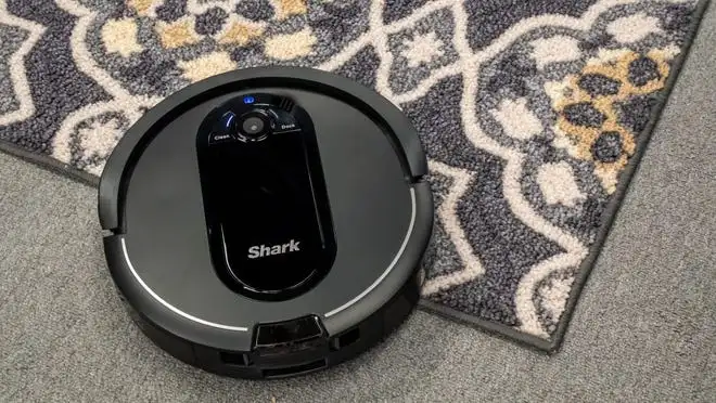A Shark IQ AV1010AE Robot Vacuum cleaning a carpet.