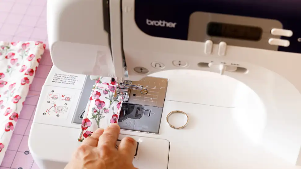Close-up photo of the writer using a sewing machine.