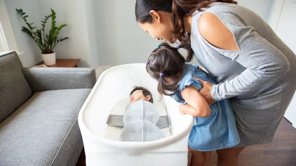 A mother and her children (the smaller of whom is nestled comfortably in a bassinet).