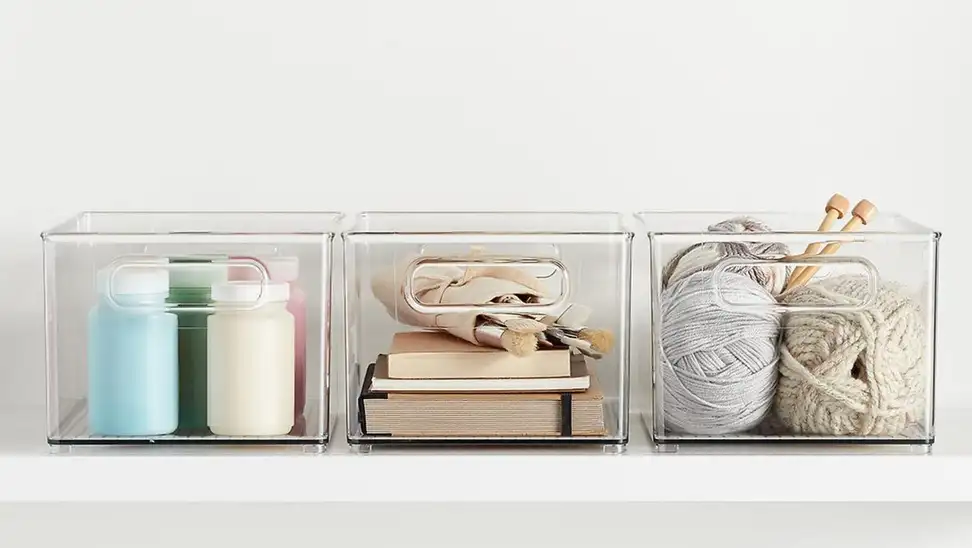 Clear containers on shelf holding craft items.
