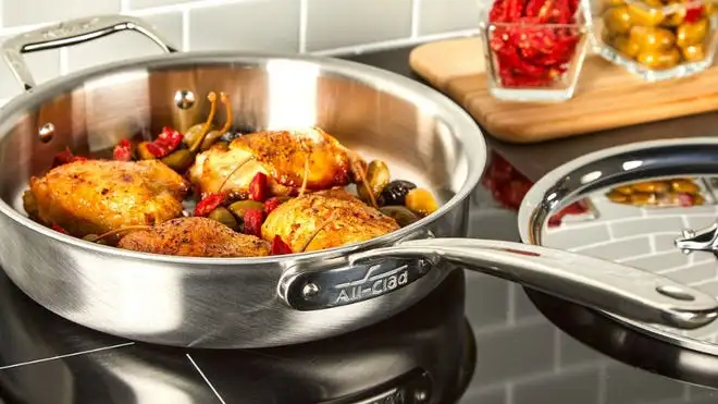 Food cooking in silver skillet on top of stovetop.