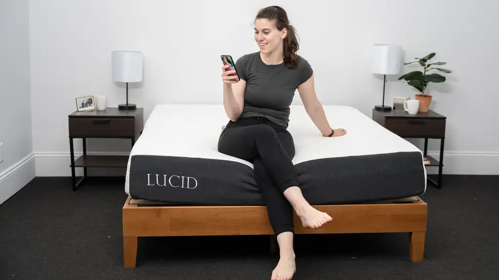 a person sits on the edge of the Lucid mattress