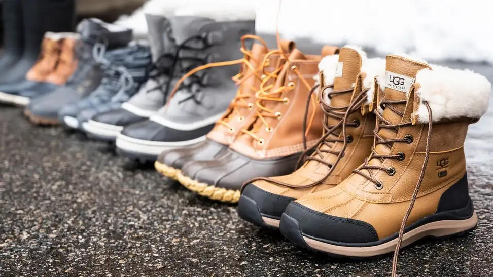 Winter boots lined up against snow.