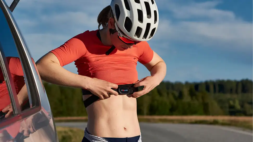 A woman attaching the Polar H10 heart rate monitor before a bike ride.