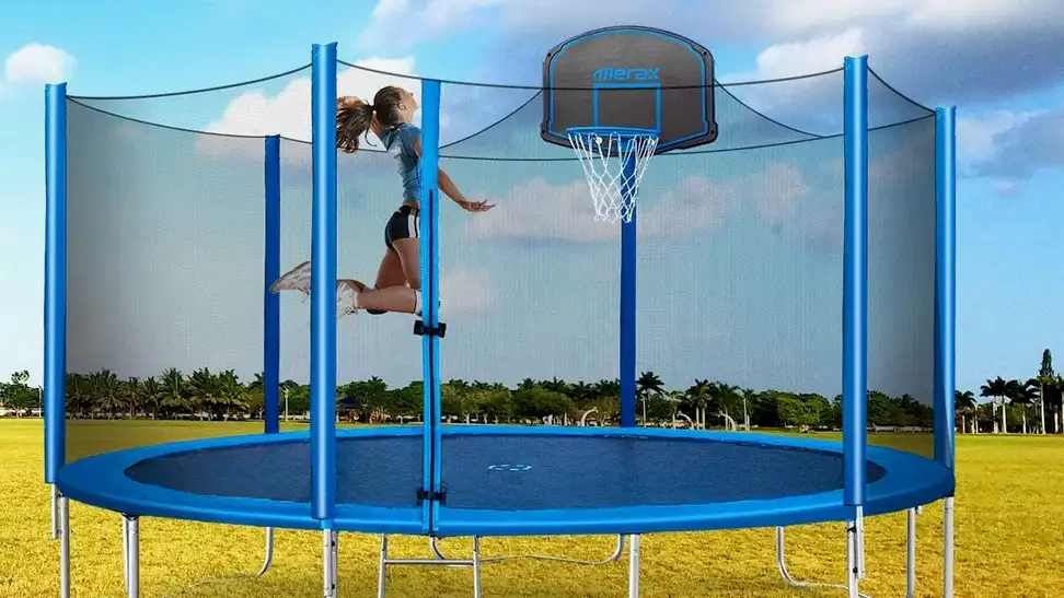 Photo of a young person enjoying a trampoline with a built-in basketball hoop.