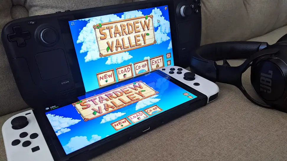 Two handheld gaming consoles next to a wireless headset