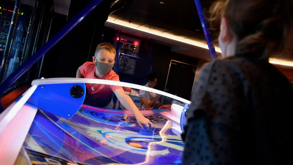 A child enjoys a game of air hockey.