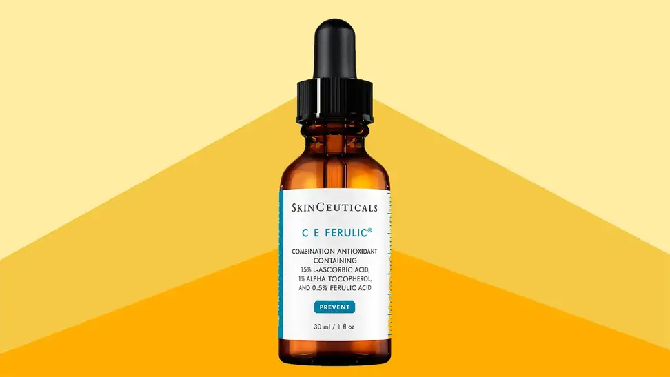 A amber glass bottle of serum in front of a background that's three shades of yellow deepening from top to bottom.