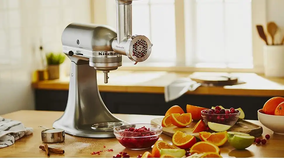 A person is using a meat grinder in their kitchen to prepare dinner.