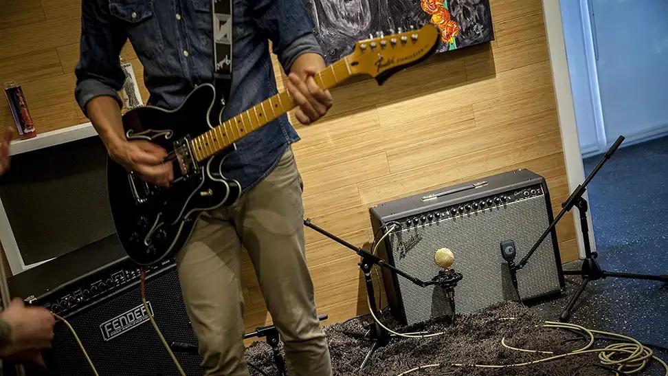 A guy practicing a song in his studio for an upcoming gig.