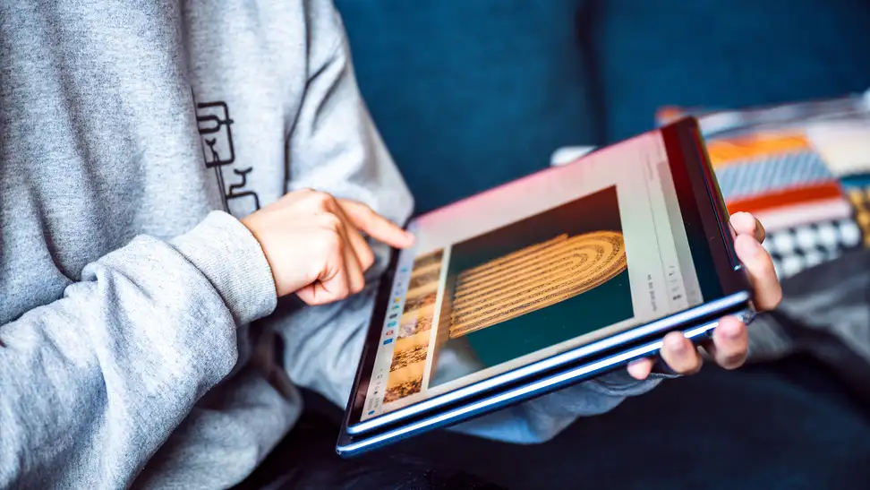 Person holds the laptop in their hands in tablet mode