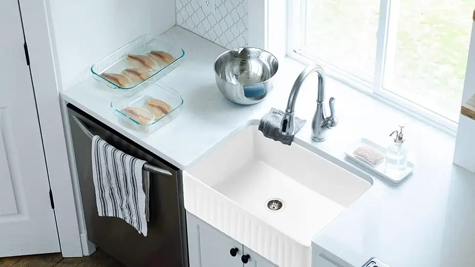 A farm sink placed in a lovely white-interior kitchen.