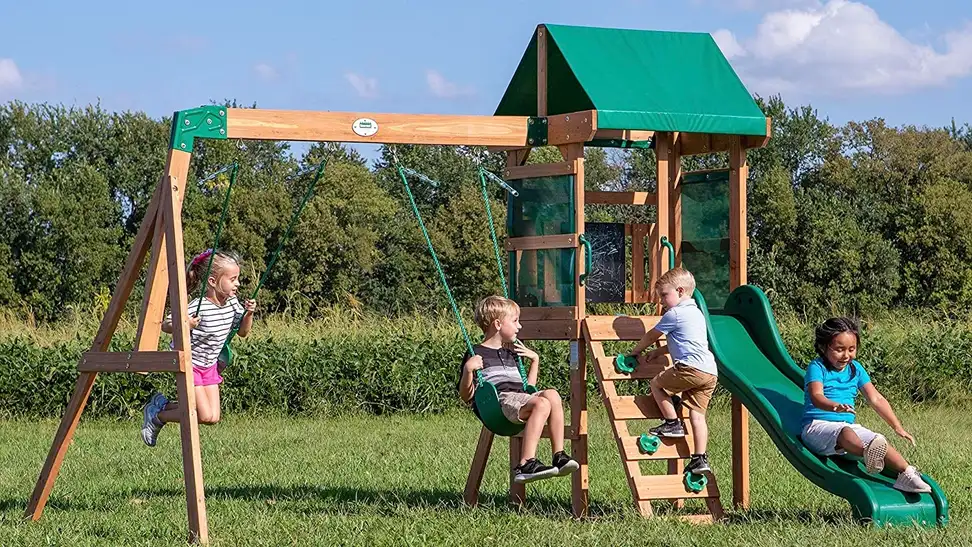 A group of kids playing on a backyard swing set.