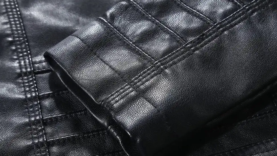 Close-up on a pleated black sleeve, which shows the texture of a Tanming leather jacket.