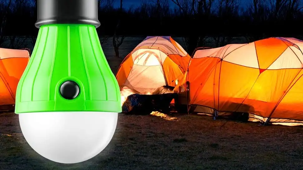 A camping lantern being used by a family at a campsite.