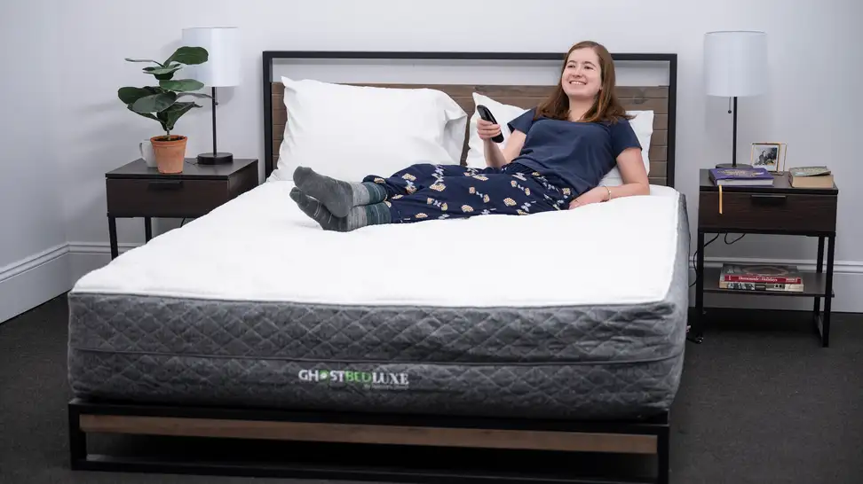 A woman laying on top of the GhostBed Luxe.